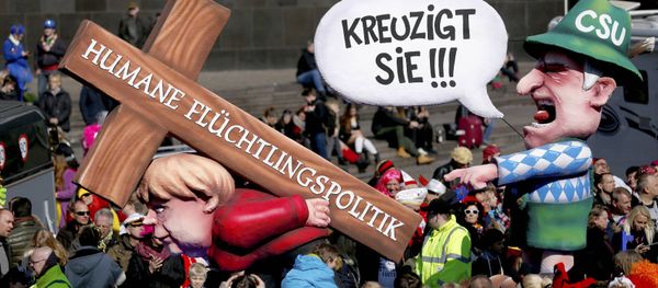 A carnival float with papier-mache caricature mocking German Chancellor Angela Merkel is displayed at a postponed Rosenmontag (Rose Monday) parade, at one location in Duesseldorf, Germany, March 13, 2016. Words read 'Crucify her' 'Humane politics for migrants' - Sputnik International