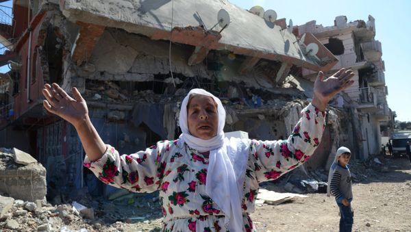 A woman reacts while walking among the rubble of damaged buildings following heavy fighting between government troops and Kurdish fighters in the Kurdish town of Cizre in southeastern Turkey, which lies near the border with Syria and Iraq, on March 2, 2016 - Sputnik International