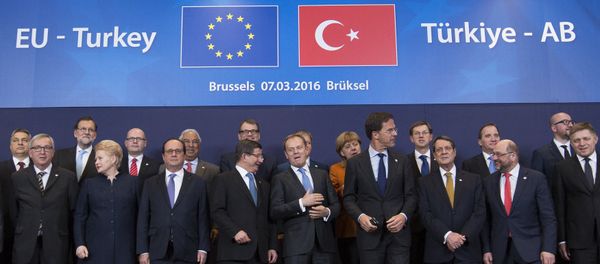 Turkish Prime Minister Ahmet Davutoglu (C) poses with European Union leaders during a EU-Turkey summit in Brussels, as the bloc is looking to Ankara to help it curb the influx of refugees and migrants flowing into Europe, March 7, 2016 - Sputnik International
