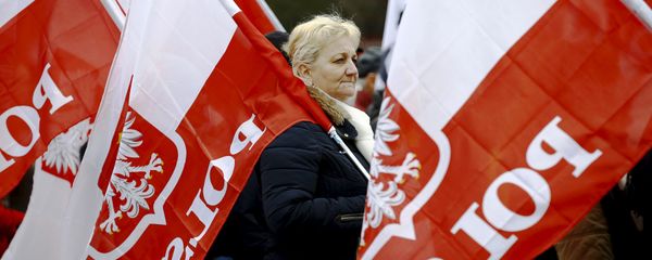 A woman holds the Polish national flag as she takes part in a march demanding their government to respect the country's constitution in Warsaw, Poland, March 12, 2016. - Sputnik International