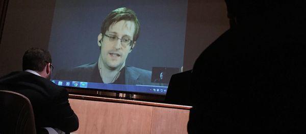 Former National Security Agency contractor Edward Snowden, center speaks via video conference to people in the Johns Hopkins University auditorium, Wednesday, Feb. 17, 2016, in Baltimore - Sputnik International
