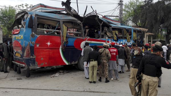 Policemen and rescue officials walk near a bus damaged in a bomb blast in Peshawar, Pakistan March 16, 2016 Policemen and rescue officials walk near a bus damaged in a bomb blast in Peshawar, Pakistan March 16, 2016 - Sputnik International