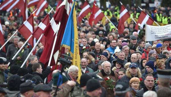 Veterans of the Latvian Legion, a force that was commanded by the German Nazi Waffen SS during WWII, and their sympathizers carry flowers as they walk to the Monument of Freedom in Riga, Latvia on March 16, 2016 - Sputnik International
