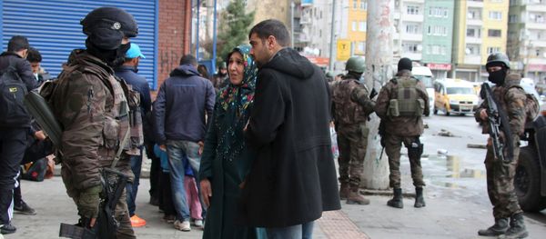 Residents talk to a member of Turkish police special forces as they flee after clashes between security forces and Kurdish militants from Baglar district, which is partially under curfew, in the Kurdish-dominated southeastern city of Diyarbakir, Turkey March 15, 2016 - Sputnik International