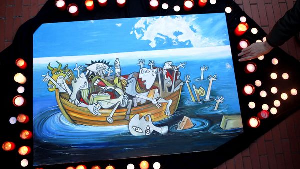 A woman places a candle next to a painting, based on a Picasso painting titled Guernica, depicting the sinking of a boat carrying immigrants during a protest against the EU-Turkey migrant deal in Malaga, southern Spain, March 16, 2016. - Sputnik International
