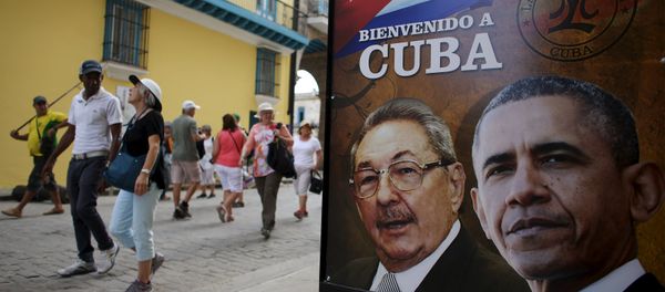 Tourists pass by images of U.S. President Barack Obama and Cuban President Raul Castro in a banner that reads Welcome to Cuba at the entrance of a restaurant in downtown Havana, March 17, 2016. - Sputnik International