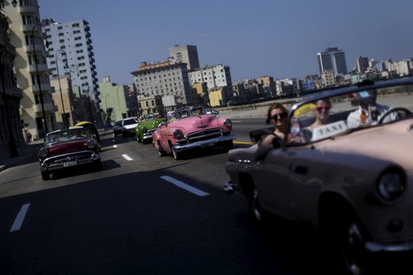 Tourists ride in a vintage car at the 'Malecon' seafront in Havana, March 16, 2016. - Sputnik International