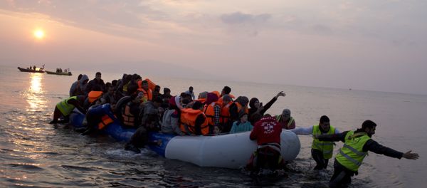 Volunteers help migrants and refugees on a dingy as they arrive at the shore of the northeastern Greek island of Lesbos, after crossing the Aegean sea from Turkey on Sunday, March 20, 2016 Volunteers help migrants and refugees on a dingy as they arrive at the shore of the northeastern Greek island of Lesbos, after crossing the Aegean sea from Turkey on Sunday, March 20, 2016 - Sputnik International