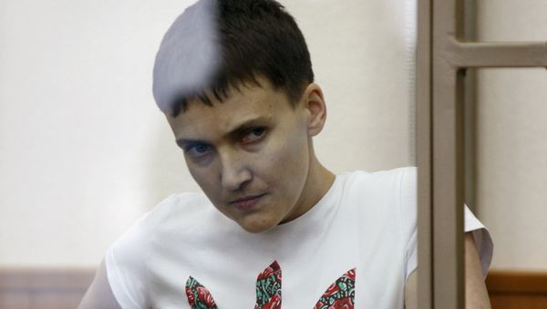 Former Ukrainian army pilot Nadezhda Savchenko looks out from a glass-walled cage as she attends a court hearing in the southern border town of Donetsk in Rostov region, Russia, in this file picture taken March 9, 2016 - Sputnik International