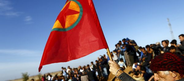 A Turkish Kurd holds a flag during the funeral of three Kurdish fighters killed during clashes in Kobani, in this October 23, 2014. - Sputnik International