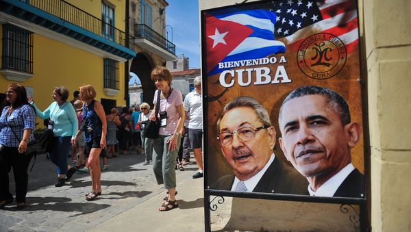 Tourists walk next to a poster of Cuban President Raul Castro and US president Barack Obama in Havana, on March 18, 2016 Tourists walk next to a poster of Cuban President Raul Castro and US president Barack Obama in Havana, on March 18, 2016 - Sputnik International