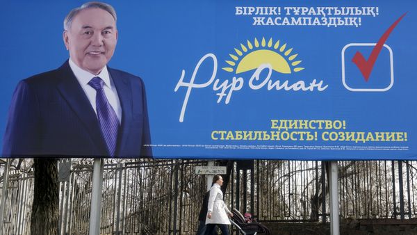 A family walks past an election poster of ruling Nur Otan party depicting Kazakhstan's President Nursultan Nazarbayev ahead of the snap parliamentary election scheduled on March 20, in Almaty, Kazakhstan, March 11, 2016 - Sputnik International