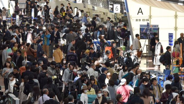 People wait in long queues to check in and get new reservations in front of counters for Japanese carrier All Nippon Airways (ANA) on the departures level of Haneda Airport in Tokyo on March 22, 2016 - Sputnik International