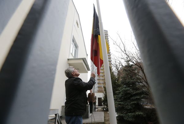 An embassy worker moves the Belgian flag to half mast in tribute to victims of the Brussels attacks, at the Belgian embassy in Moscow, Russia, March 22, 2016 - Sputnik International