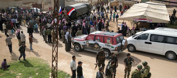 People gather around a Russian military truck to receive a food aid in Maarzaf, about 15 kilometers west of Hama, Syria, Wednesday, March 2, 2016 - Sputnik International