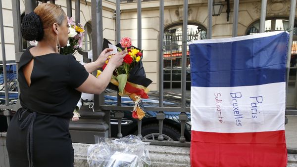 A woman leaves a bouquet of flowers in the Belgian national colours next to a French national flag with the lettering 'Paris - Brussels - Solidarity' at the fence of the Belgian embassy in Paris on March 22, 2016 A woman leaves a bouquet of flowers in the Belgian national colours next to a French national flag with the lettering 'Paris - Brussels - Solidarity' at the fence of the Belgian embassy in Paris on March 22, 2016 - Sputnik International