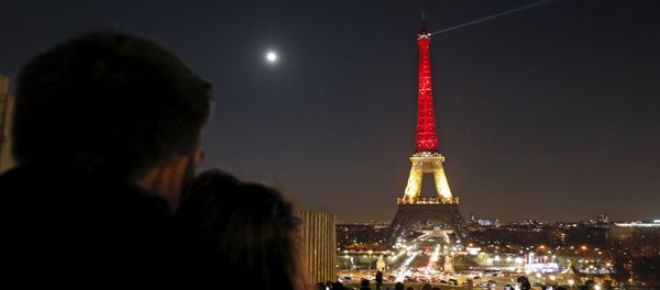 A couple looks at the Eiffel Tower lit up in the colours of the Belgian flag in tribute to the victims of today's bomb attacks in Brussels, in Paris, France, March 22, 2016 A couple looks at the Eiffel Tower lit up in the colours of the Belgian flag in tribute to the victims of today's bomb attacks in Brussels, in Paris, France, March 22, 2016 - Sputnik International