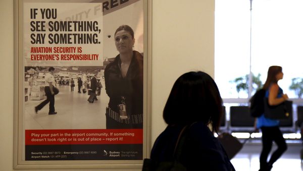 A poster regarding airport security hangs from a wall as passengers walk around the departures area at Sydney International Airport, Australia, March 23, 2016. A poster regarding airport security hangs from a wall as passengers walk around the departures area at Sydney International Airport, Australia, March 23, 2016. - Sputnik International