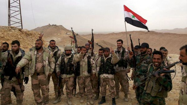 Forces loyal to Syria's President Bashar al-Assad flash victory signs and carry a Syrian national flag on the edge of the historic city of Palmyra in Homs Governorate, in this handout picture provided by SANA on March 26, 2016. Forces loyal to Syria's President Bashar al-Assad flash victory signs and carry a Syrian national flag on the edge of the historic city of Palmyra in Homs Governorate, in this handout picture provided by SANA on March 26, 2016. - Sputnik International
