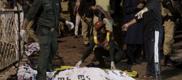 Rescue workers move a body from the site of a blast outside a public park in Lahore, Pakistan Rescue workers move a body from the site of a blast outside a public park in Lahore, Pakistan - Sputnik International