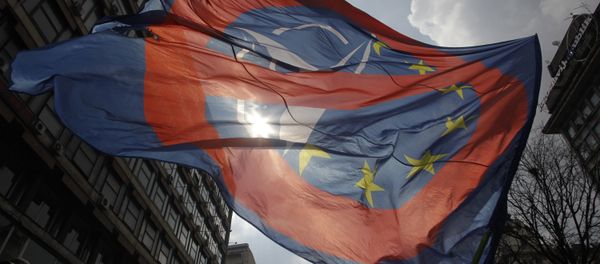 A man waves an anti NATO and EU flag during an anti NATO rally in downtown Belgrade, Serbia, March 27, 2016. A man waves an anti NATO and EU flag during an anti NATO rally in downtown Belgrade, Serbia, March 27, 2016. - Sputnik International