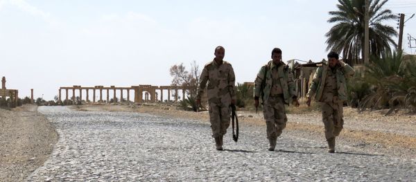 Syrian troops walk in the ancient city of Palmyra after they recaptured the site from the Islamic State (IS) group on March 27, 2016 - Sputnik International
