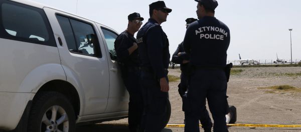 Cypriot policemen stand guard in the vicinity of Larnaca airport where an EgyptAir Airbus A-320 (R) sits on the tarmac after being hijacked and diverted to Cyprus on March 29, 2016 - Sputnik International