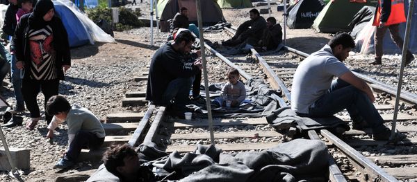 Migrants and refugees block the railway tracks as they protest in makeshift camp at the Greek-Macedonian border, near the Greek village of Idomeni on March 30, 2016, where thousands of them are stranded by the Balkan border blockade - Sputnik International