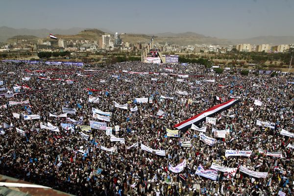 Yemenis wave national flags and hold placards during a protest against the Saudi-led coalition, commemorating one year of the alliance's military campaign against insurgents on March 26, 2016 next to the Monument to the Unknown Soldier in the Yemeni capital Sanaa - Sputnik International