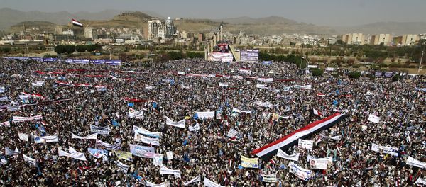 Yemenis wave national flags and hold placards during a protest against the Saudi-led coalition, commemorating one year of the alliance's military campaign against insurgents on March 26, 2016 next to the Monument to the Unknown Soldier in the Yemeni capital Sanaa Yemenis wave national flags and hold placards during a protest against the Saudi-led coalition, commemorating one year of the alliance's military campaign against insurgents on March 26, 2016 next to the Monument to the Unknown Soldier in the Yemeni capital Sanaa - Sputnik International