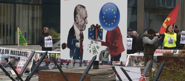 A picture taken on March 18, 2016 shows a placard depicting German Chancellor Angela Merkel (R) giving money to Turkish President Recep Tayyip Erdogan and reading not to be accomplices to crime, involves supporting peace, democracy and human rights as Kurdish people take part in a protest to call for an end of the Turkish State terror in Kurdistan, during the European Union summit in Brussels A picture taken on March 18, 2016 shows a placard depicting German Chancellor Angela Merkel (R) giving money to Turkish President Recep Tayyip Erdogan and reading not to be accomplices to crime, involves supporting peace, democracy and human rights as Kurdish people take part in a protest to call for an end of the Turkish State terror in Kurdistan, during the European Union summit in Brussels - Sputnik International