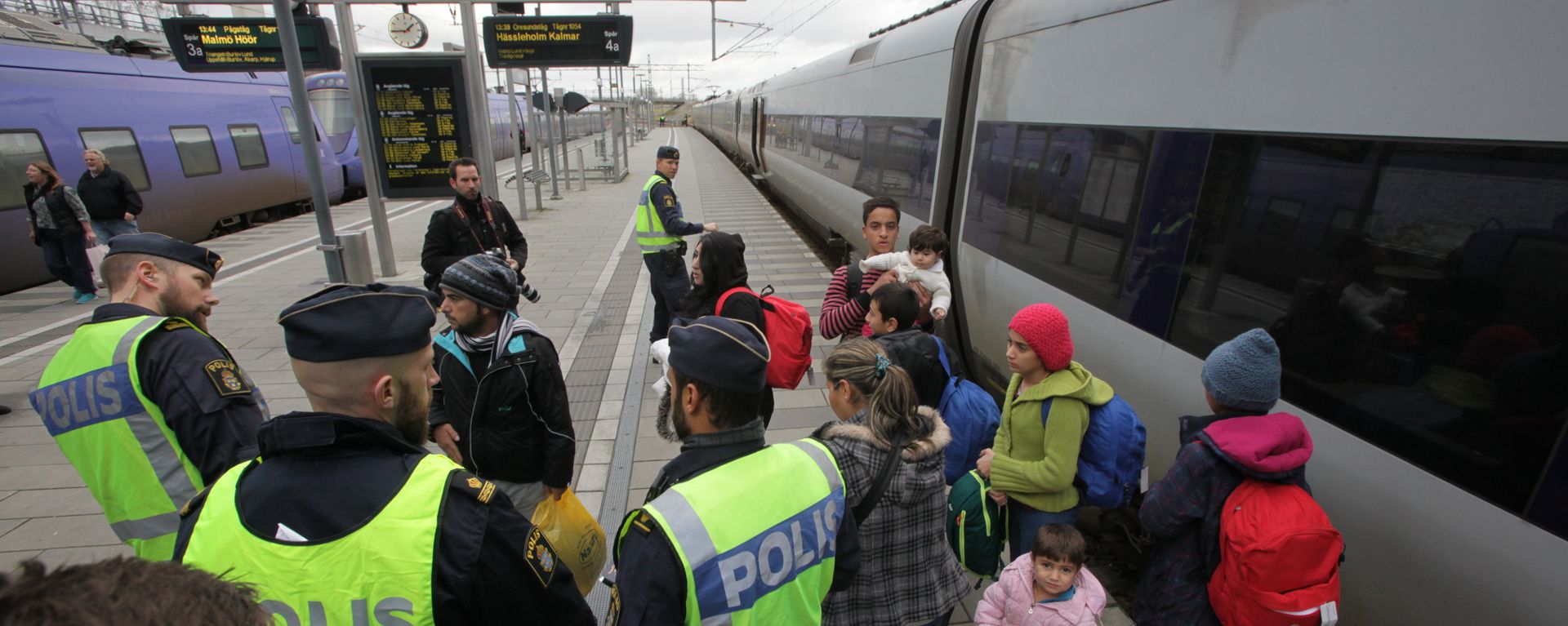 Policemen and a group of migrants stand on the platform at the Swedish end of the bridge between Sweden and Denmark in Malmo, Sweden, on November 12, 2015 Policemen and a group of migrants stand on the platform at the Swedish end of the bridge between Sweden and Denmark in Malmo, Sweden, on November 12, 2015 - Sputnik International, 1920, 25.01.2023