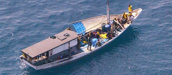 Turkish Kurd refugees on an Indonesian fishing boat are guarded by Navy personnel 20 kms off Melville Island, near the northern mainland city of Darwin. The fate of the refugees suspected to be seeking asylum in Australia was unknown after they sailed into a legal storm over the country's tough immigration laws - Sputnik International