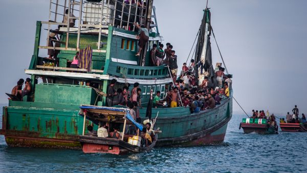 In this photo taken on May 20, 2015 shows Rohingya migrants resting on a boat off the coast near Kuala Simpang Tiga in Indonesia's East Aceh district of Aceh province before being rescued. Indonesia's foreign minister demanded answers from Canberra about claims Australian officials paid thousands of dollars to turn a boat back to Indonesia after Prime Minister Tony Abbott refused to deny the allegations - Sputnik International