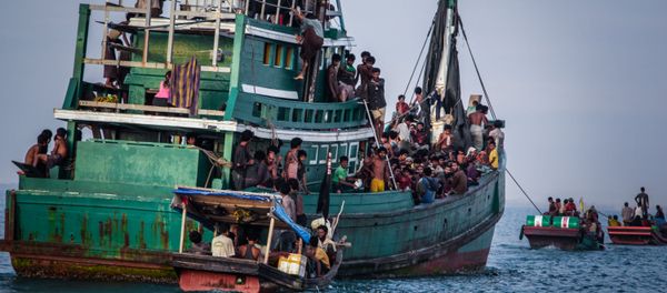 In this photo taken on May 20, 2015 shows Rohingya migrants resting on a boat off the coast near Kuala Simpang Tiga in Indonesia's East Aceh district of Aceh province before being rescued. Indonesia's foreign minister demanded answers from Canberra about claims Australian officials paid thousands of dollars to turn a boat back to Indonesia after Prime Minister Tony Abbott refused to deny the allegations In this photo taken on May 20, 2015 shows Rohingya migrants resting on a boat off the coast near Kuala Simpang Tiga in Indonesia's East Aceh district of Aceh province before being rescued. Indonesia's foreign minister demanded answers from Canberra about claims Australian officials paid thousands of dollars to turn a boat back to Indonesia after Prime Minister Tony Abbott refused to deny the allegations - Sputnik International