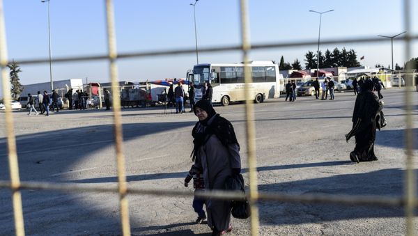 A Syrian woman and a child walks back towards the Syrian crossing, on February 8, 2016 at Turkish Oncupinar border gate near Kilis, southern-central Turkey - Sputnik International