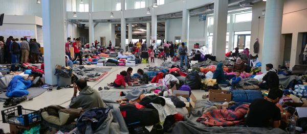 Migrants and refugees rest at the passengers terminal at the port of Piraeus where more than 5,500 migrants and refugees have found temporary shelter on March 30, 2016 - Sputnik International