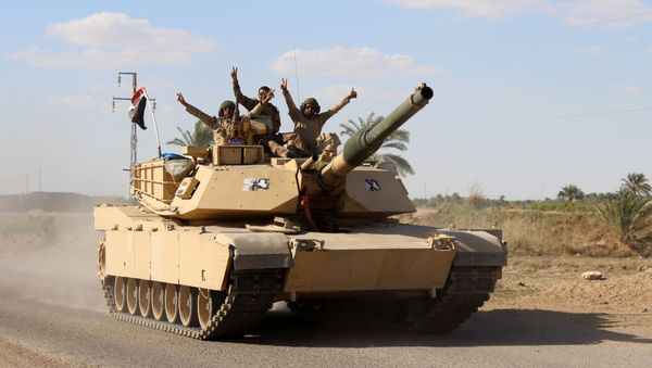 Iraqi government forces gesture from their vehicles in the village of Mohammadi, a few miles north of Hit, in Iraq's western province of Anbar on March 18, 2016 - Sputnik International