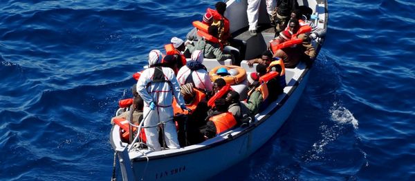 Migrants sit on a rescue boat during a rescue operation of migrants by Italian Navy vessels in this March 18, 2016 handout picture. - Sputnik International
