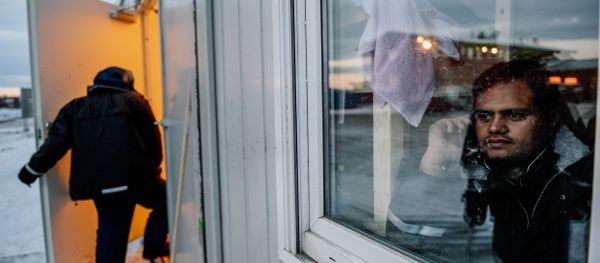 A refugee looks through a window at the arrival centre for refugees near the town on Kirkenes in northern Norway A refugee looks through a window at the arrival centre for refugees near the town on Kirkenes in northern Norway - Sputnik International