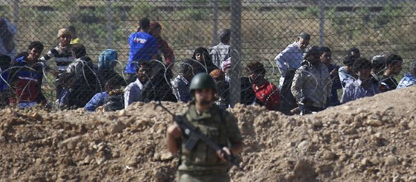 File photo of a Turkish army soldier guards the border area with Syria as in the background Syrian refugees wait in Syria in order to cross into Turkey, in Akcakale, southeastern Turkey, Monday, June 15, 2015 File photo of a Turkish army soldier guards the border area with Syria as in the background Syrian refugees wait in Syria in order to cross into Turkey, in Akcakale, southeastern Turkey, Monday, June 15, 2015 - Sputnik International