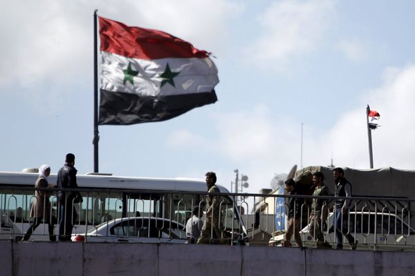 People walk near a Syrian national flag at the President bridge in Damascus, Syria March 14, 2016 - Sputnik International