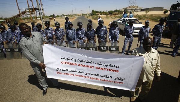 Sudanese police stand guard as two men hold a banner outside the US embassy in the capital Khartoum on November 3, 2015, to protest against sanctions imposed on their country by the United States Sudanese police stand guard as two men hold a banner outside the US embassy in the capital Khartoum on November 3, 2015, to protest against sanctions imposed on their country by the United States - Sputnik International
