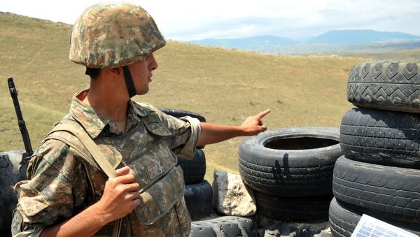 An Armenian soldier of the self-proclaimed republic of Nagorno-Karabagh stands in a trench at the frontline on the border with Azerbaijan near the town of Martakert, on July 6, 2012. - Sputnik International