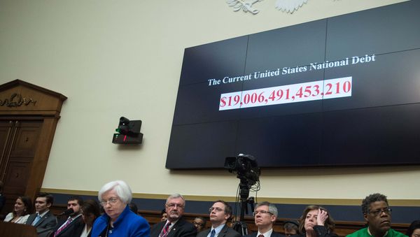 A screen shows the US national debt before US Federal Reserve chair Janet Yellen (front L) testifies before the House Financial Services Committee on Capitol Hill in Washington, DC, on February 10, 2016. A screen shows the US national debt before US Federal Reserve chair Janet Yellen (front L) testifies before the House Financial Services Committee on Capitol Hill in Washington, DC, on February 10, 2016. - Sputnik International