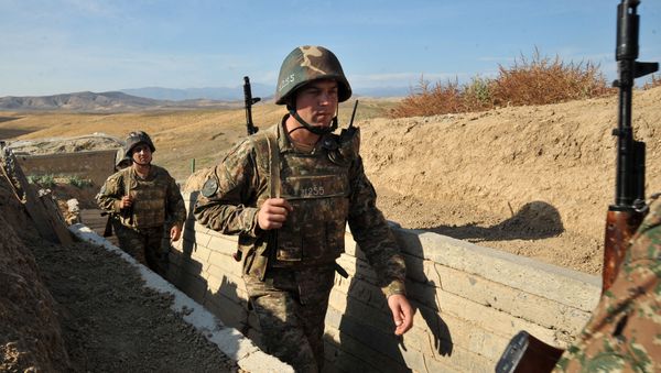 Armenian soldiers of the self-proclaimed republic of Nagorno-Karabakh walking in trenches at the frontline on the border with Azerbaijan. - Sputnik International
