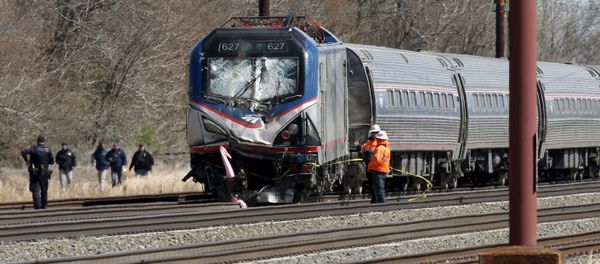 Emergency personnel examine the scene after an Amtrak passenger train struck a backhoe, killing two people, in Chester, Pennsylvania - Sputnik International