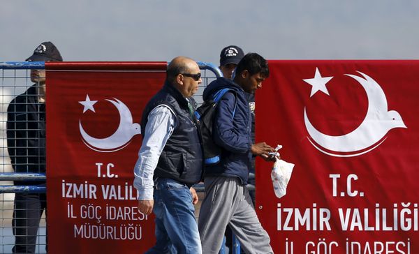 A migrant is escorted by a Turkish police officer as he arrives in the Turkish coastal town of Dikili, Turkey, April 4, 2016 A migrant is escorted by a Turkish police officer as he arrives in the Turkish coastal town of Dikili, Turkey, April 4, 2016 - Sputnik International