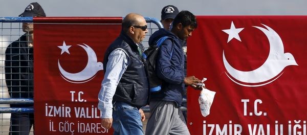 A migrant is escorted by a Turkish police officer as he arrives in the Turkish coastal town of Dikili, Turkey, April 4, 2016 - Sputnik International