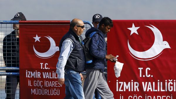 A migrant is escorted by a Turkish police officer as he arrives in the Turkish coastal town of Dikili, Turkey, April 4, 2016 A migrant is escorted by a Turkish police officer as he arrives in the Turkish coastal town of Dikili, Turkey, April 4, 2016 - Sputnik International